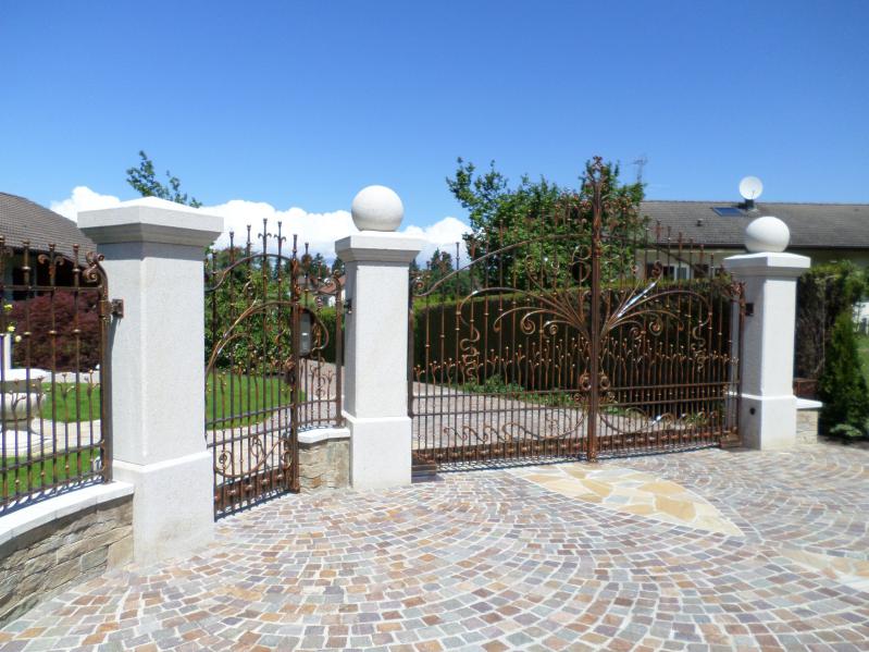 L'entrée de la propriété est aménagée avec des piliers en pierre sotenant un portail