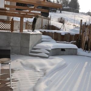 Piscine naturelle en hiver, sous la neige. Création d'une piscine naturelle en montagne.