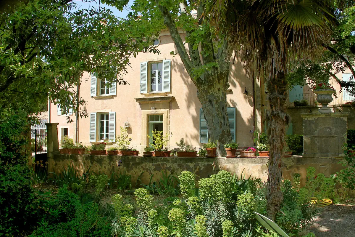 Casa Harmas Jean-Henri Fabre văzută prin vegetația grădinii din Sérignan-du-Comtat