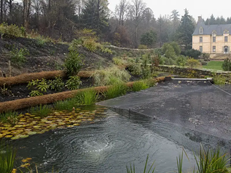 Bassin de jardin couvert d’un filet avec aération et fascines retenant le ruissellement